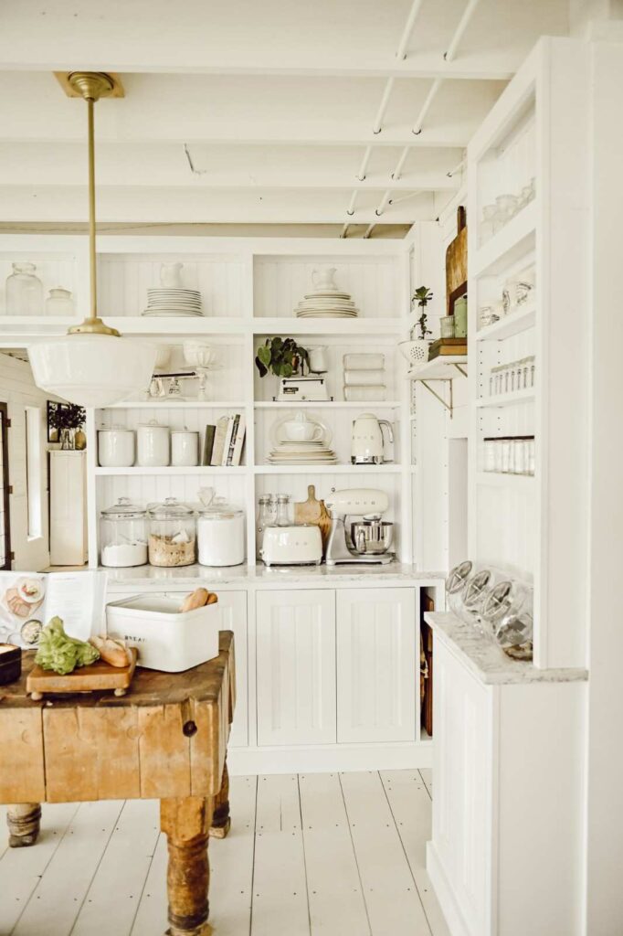 White open shelves with neatly arranged jars and cookbooks-small kitchen ideas on a budget
